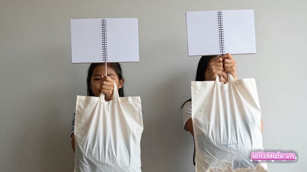 Một người học Việt Nam đặt hai quả cân trơn hai bên bàn, ghi chú vào sổ trắng để cân bằng lập luận.